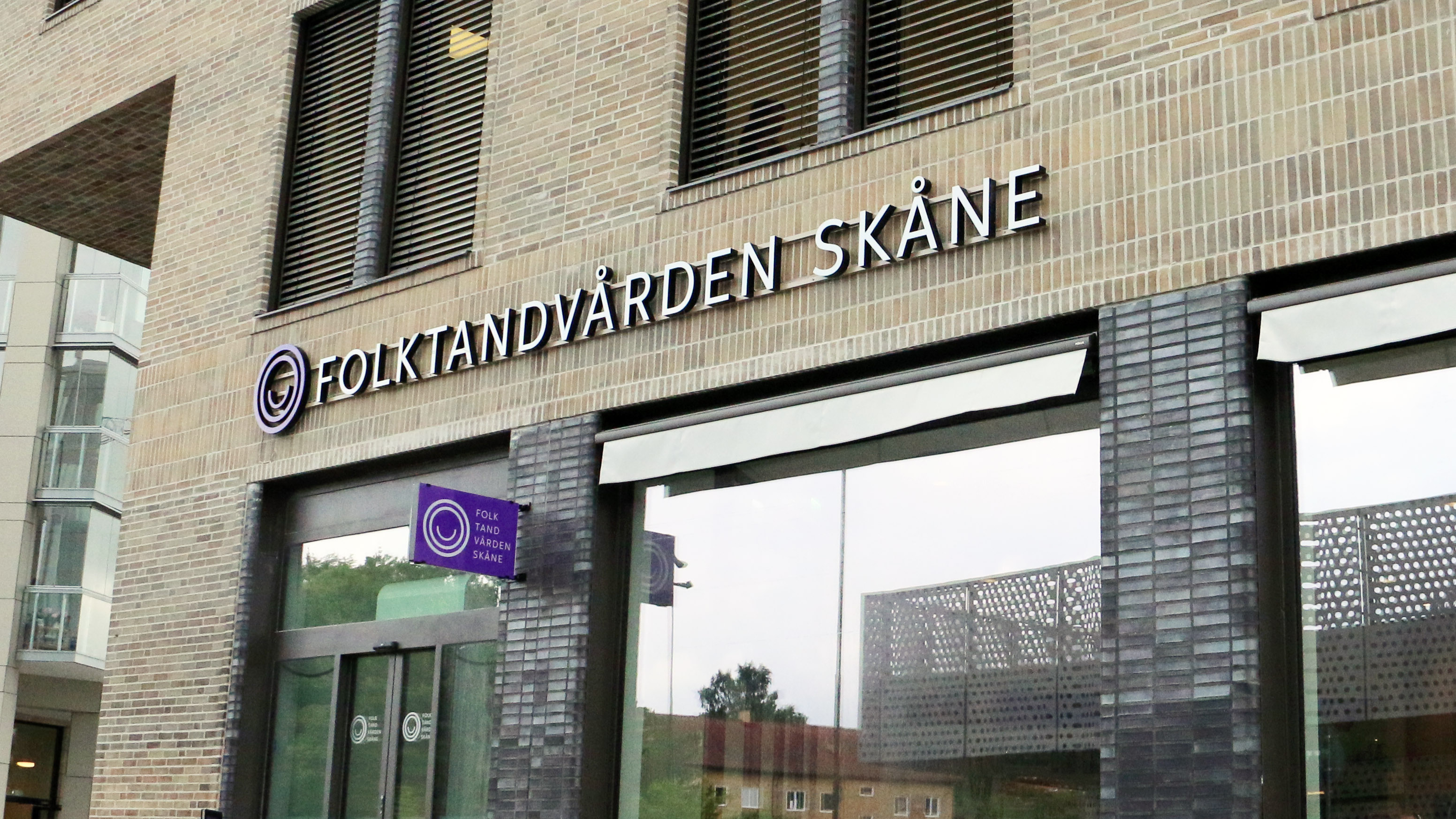 Tegelbyggnad med Folktandvården Skåne-skylt.
